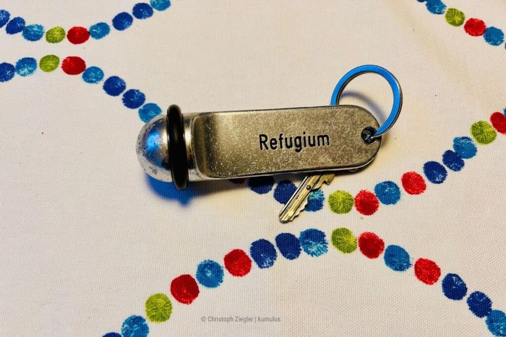 Das Bild zeigt einen Schlüssel mit der Aufschrift "Refugium" – als Metapher für einen Ort, an dem Du Selbstvertrauen aufbaust (Photocredit: eigenes Material von Christoph Ziegler, kumulus Social Media Beratung).