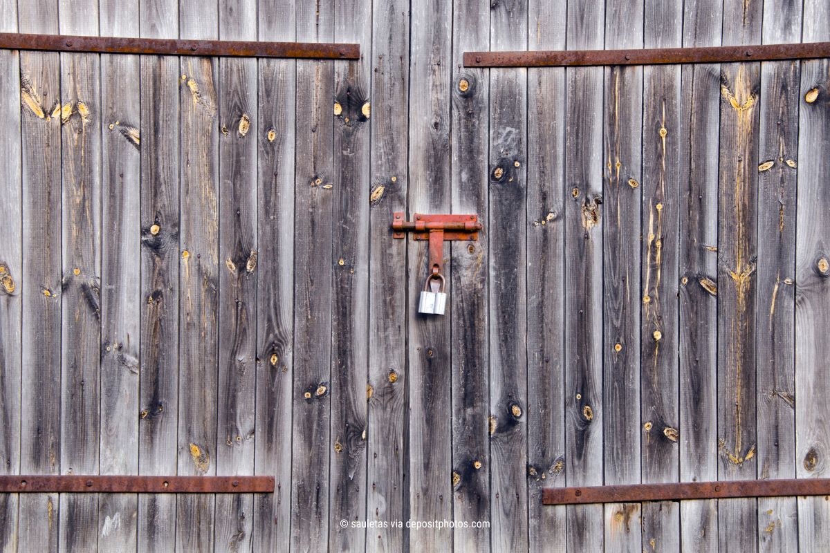 Das Bild zeigt eine Scheunentür aus Holz, die durch ein Vorhängeschloss abgeschlossen ist – als Metapher für digitale Privatsphäre (Bildquelle: sauletas via depositphotos).